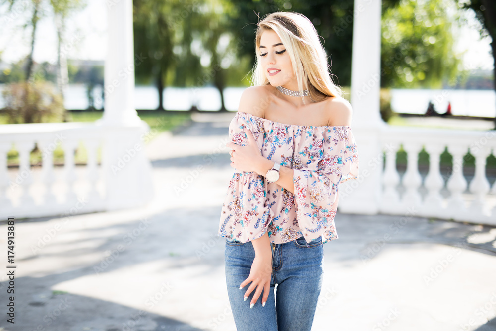 Attractive blonde young woman are walking in the city . Turn around Attractive blonde young woman are walking in the city . Turn around