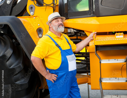 farmer in blue overalls from agricultural machinery