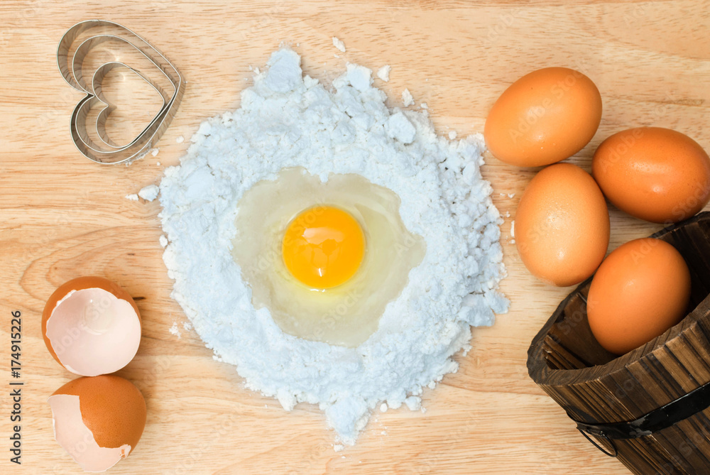 Top view composition flour with egg and ingredients for homemade bakery on wooden background Top view composition flour with egg and ingredients for homemade bakery on wooden background