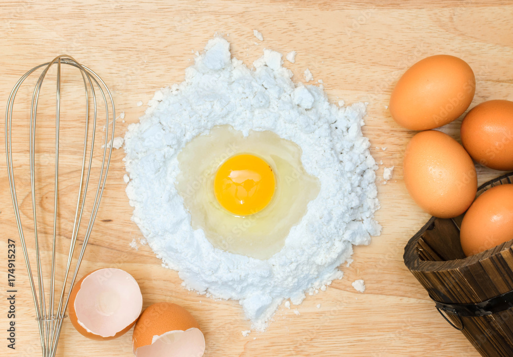 Top view composition flour with egg and ingredients for homemade bakery on wooden background Top view composition flour with egg and ingredients for homemade bakery on wooden background