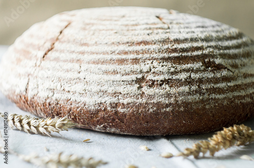 Fresh sourdough artisan bread and wheat on kitchen towel
