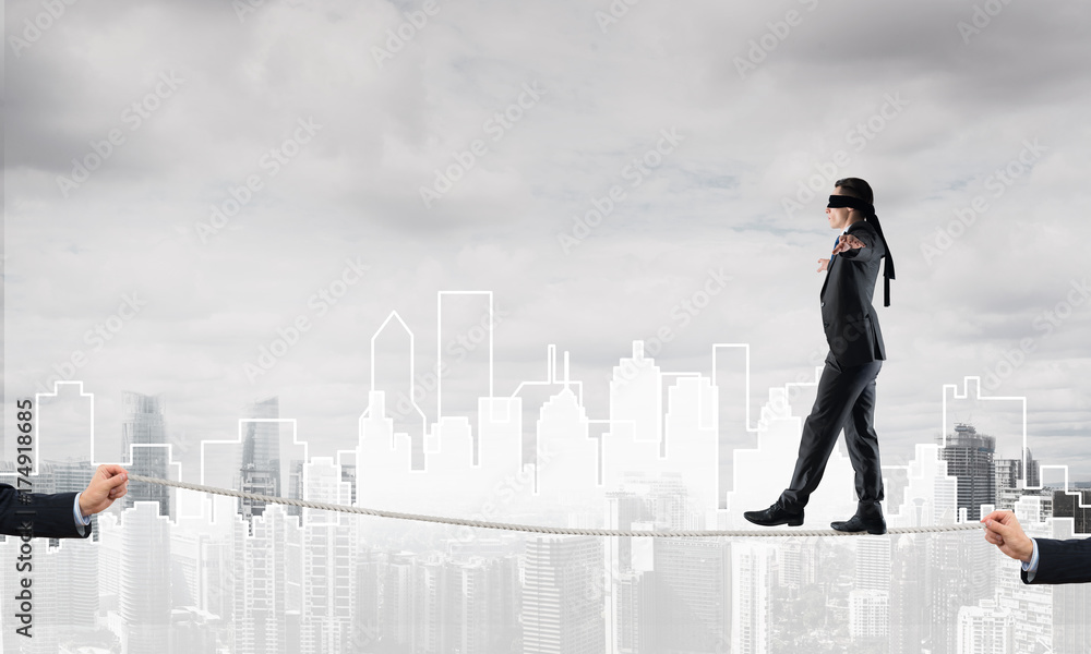 Business concept of risk support and assistance with man balancing on rope Business concept of risk support and assistance with man balancing on rope