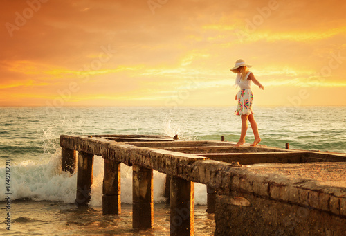 Young woman enjoys relaxing at the seaside at sunset