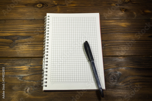 Blank notebook with ballpoint pen on wooden desk