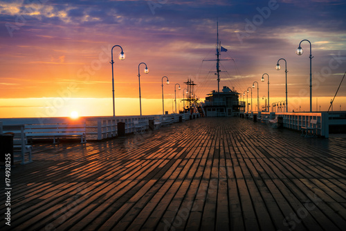 The first rays of the sun warms the wet boards of the pier in Sopot. Poland.
