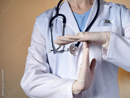 Photography A female doctor wearing rubber gloves shows a gesture time out