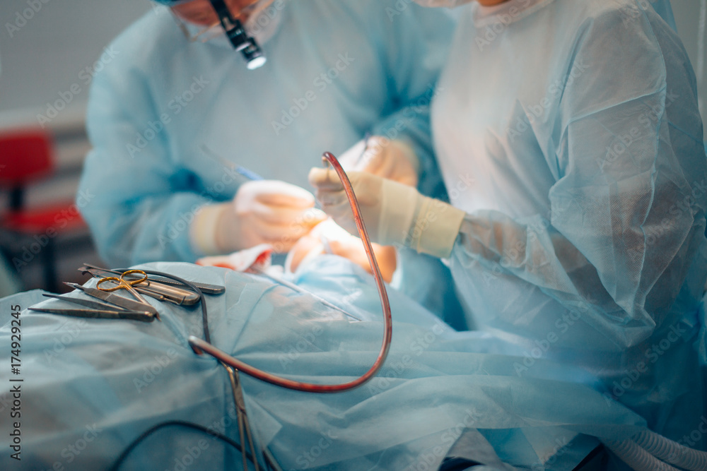Φωτογραφία Surgeon and his assistant performing cosmetic surgery on nose in hospital operating room