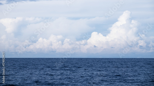 Blue sea with big white clouds and sky.