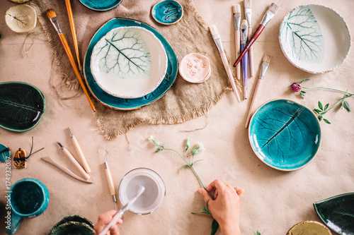 Fotografie potter woman paints ceramic cup