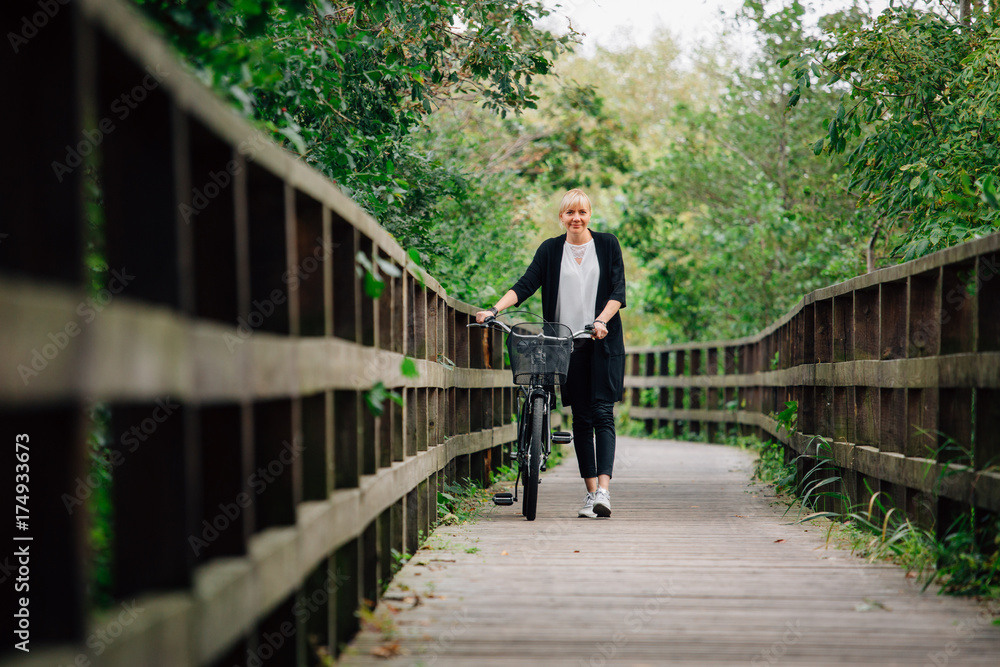Young stylish woman in black cardigan with pretty retro bicycle with basket in park. Handsome girl resting in park after ride Young stylish woman in black cardigan with pretty retro bicycle with basket in park. Handsome girl resting in park after ride