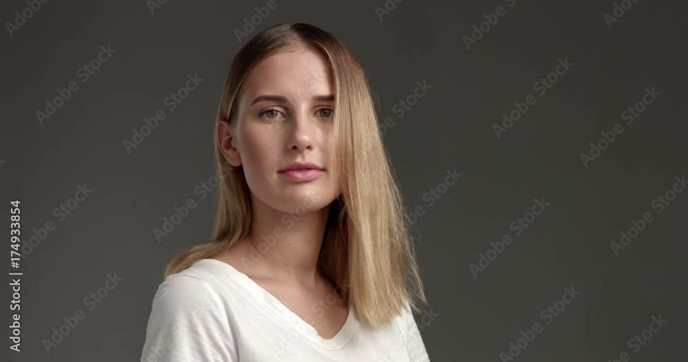 Pretty flirty blond girl in a white top isolated on dark gray trying on glasses and playing with camera Pretty flirty blond girl in a white top isolated on dark gray trying on glasses and playing with camera