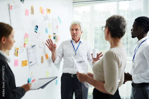 Highly professional detectives of National Transportation Safety Board gathered together at investigation board and making assumptions about possible reasons of air crash