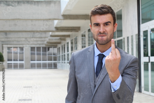 Photos Moody businessman showing a middle finger with space for copy