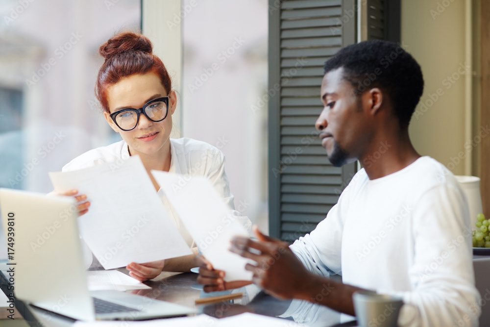 Hard-working team of financial managers analyzing statistic data while having productive working meeting at modern office lobby Hard-working team of financial managers analyzing statistic data while having productive working meeting at modern office lobby