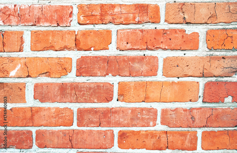 Obraz premium Texture of an old brick wall. Grunge red background of stone and cement. The shabby facade of the building with old bricks and damaged plaster. Abstract banner with copy space.