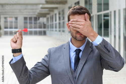 Blind businessman holding a dart 