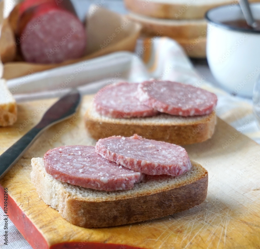 Sandwich with sausage and black tea with sugar Sandwich with sausage and black tea with sugar