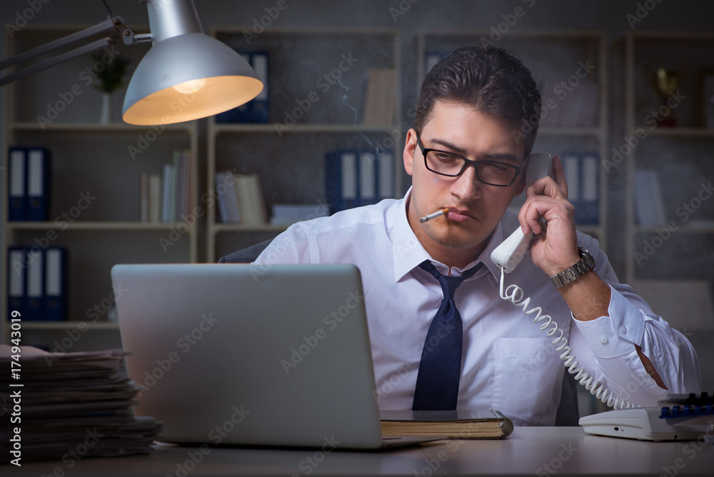 Businessman speaking on phone and smoking in office