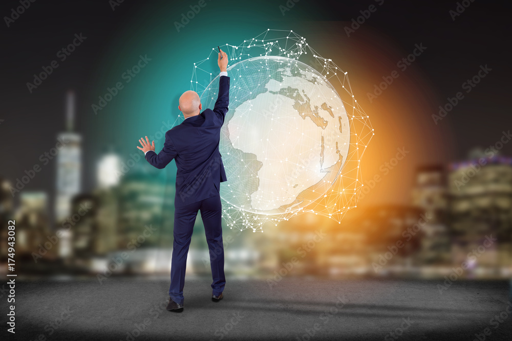 Businessman in front of a wall with International network displayed on a futuristic interface with globe and connection - technology and business concept Businessman in front of a wall with International network displayed on a futuristic interface with globe and connection - technology and business concept
