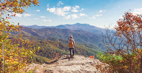 Man at the edge of a cliff overlooking the mountains below