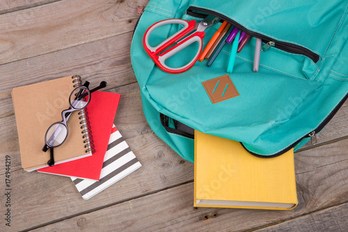 Slika na platnu Backpack and school supplies: books, pencils, notepad, felt-tip pens, eyeglasses