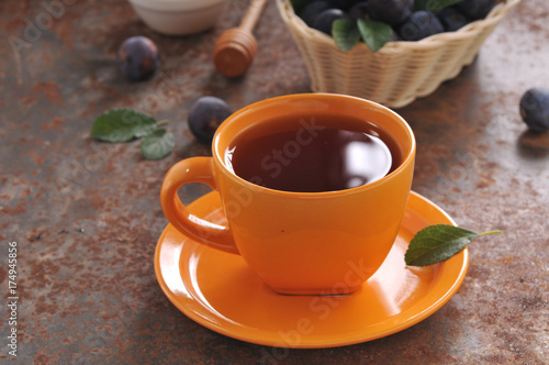 A cup of tea and plum on the table