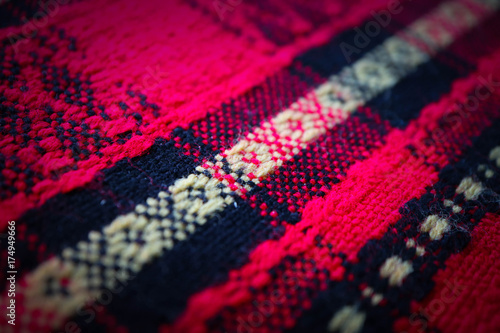 Traditional Bulgarian red color tablecloth rural fabric texture, close up. Old Macedonian ethnic textile with abstract ornament, decoration.