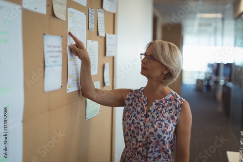 фотографія Businesswoman reading paper on notice board