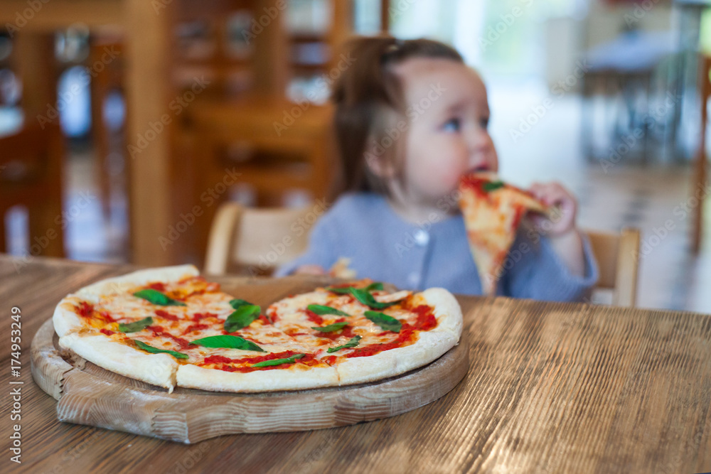 baby girl eating pizza in italian restaurant, Healthy, unhealthy food, children's fast food