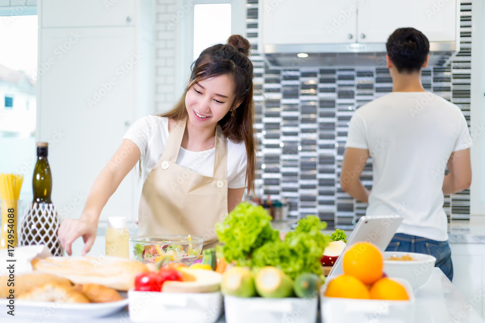 Asian couple cooking for food and salad for romantic diner in kitchen room in the home Asian couple cooking for food and salad for romantic diner in kitchen room in the home