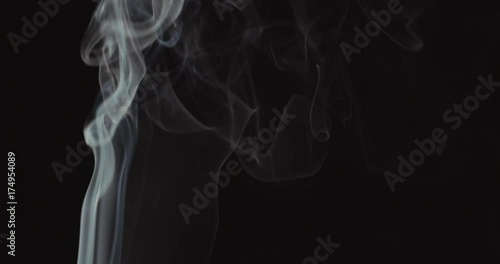 Candle blown out and white smoke rising up on black background