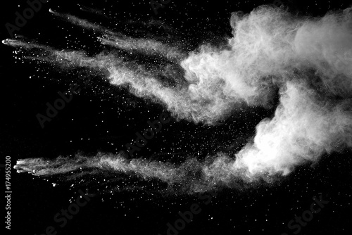 Fototapeta Explosion of white dust on black background.