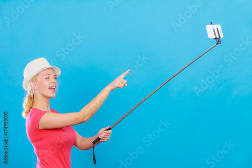 Woman taking picture of herself with phone on stick