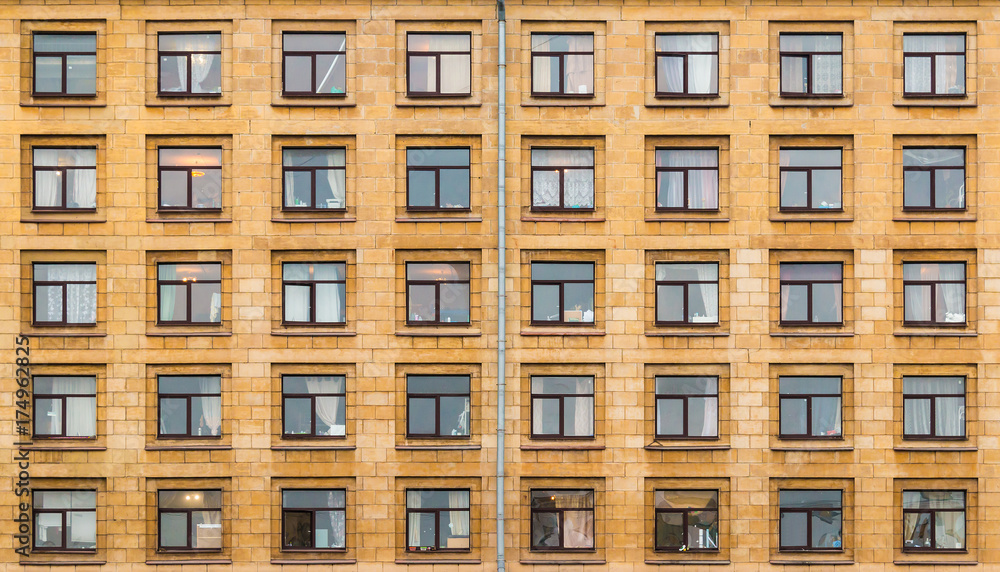 Many windows in a row on facade of urban apartment building front view, St. Petersburg, Russia