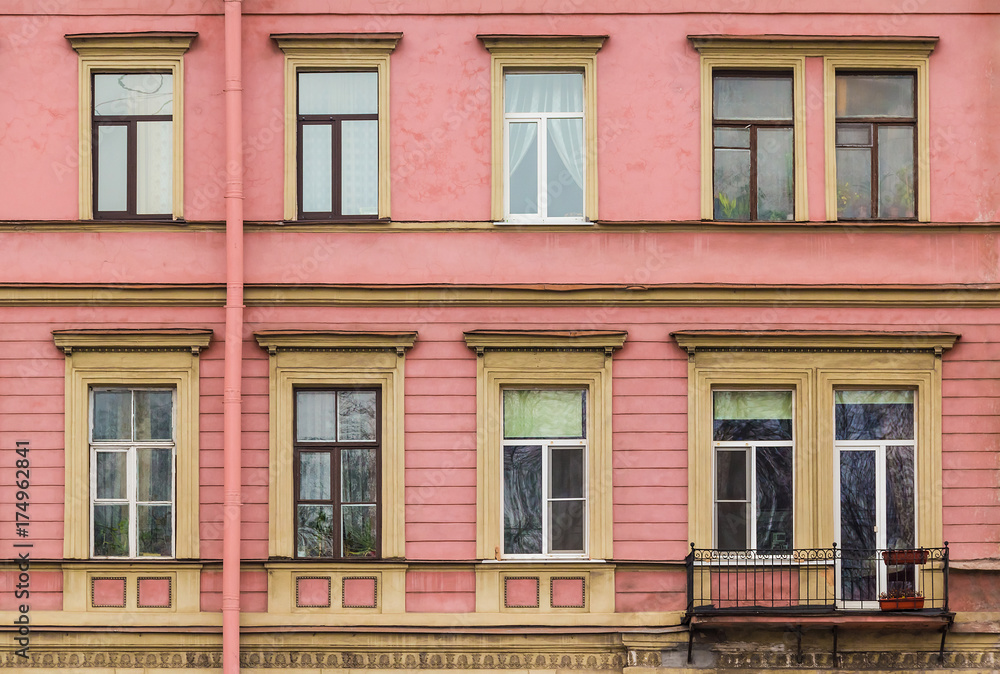 Several windows in a row and balcony on facade of urban apartment building front view, St. Petersburg, Russia Several windows in a row and balcony on facade of urban apartment building front view, St. Petersburg, Russia