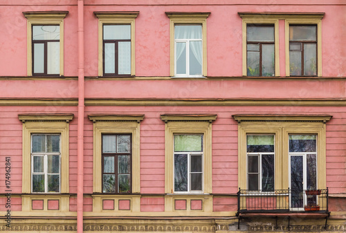 Several windows in a row and balcony on facade of urban apartment building front view, St. Petersburg, Russia © dr_verner