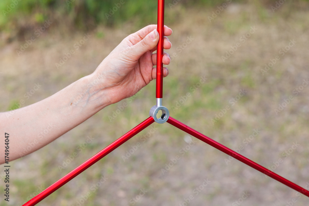 Close up detail of camping tent. Aluminum tent poles. Process of installing tent, setting up tent outdoors. Close up detail of camping tent. Aluminum tent poles. Process of installing tent, setting up tent outdoors.