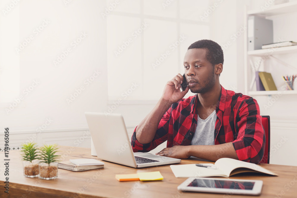 Fototapeta premium Young black businessman call mobile phone in modern white office