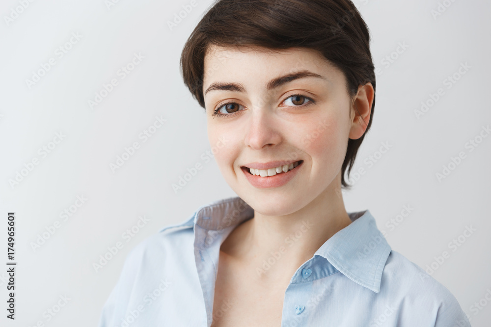 Close up portrait of good-looking young student girl with big brown eyes smiling brightfully, looking in camera with happy look. Close up portrait of good-looking young student girl with big brown eyes smiling brightfully, looking in camera with happy look.