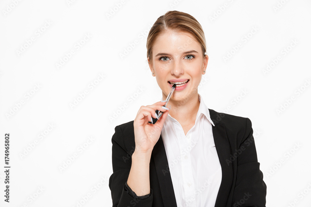 Smiling blonde business woman bites pen and looking at camera Smiling blonde business woman bites pen and looking at camera