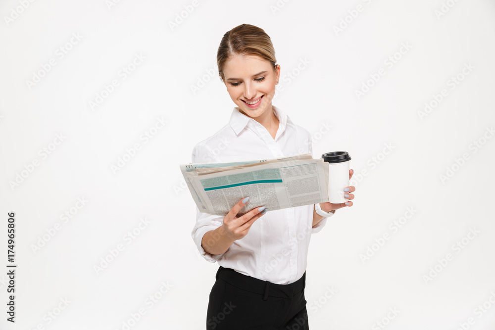 Smiling blonde business woman reading newspaper Smiling blonde business woman reading newspaper