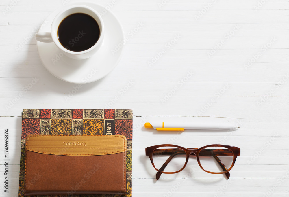 glasses, notebook, pen and cup of coffee on white wooden background glasses, notebook, pen and cup of coffee on white wooden background