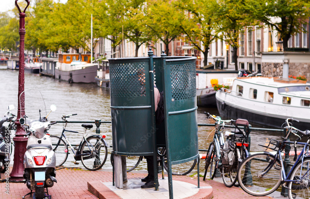Fototapeta premium Man urinating in Amsterdam in a public urinal