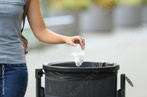 Civic woman throwing garbage in a trash bin