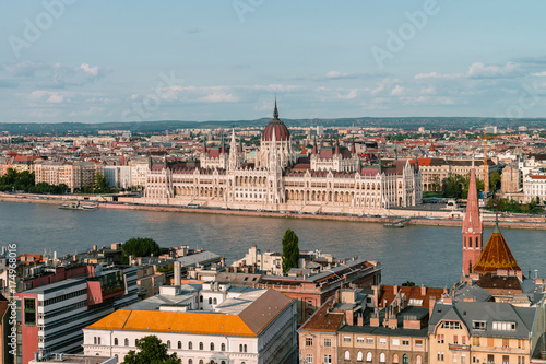 Panoramic view on the Hungarian Parliament Building on the bank of the Danube in Budapest. Sunny evening with clouds