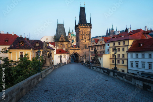 Charles Bridge in Prague in the early morning. View of Malostranska Tower and Judithin Tower. In the background on the mountain you can see Prague Castle.