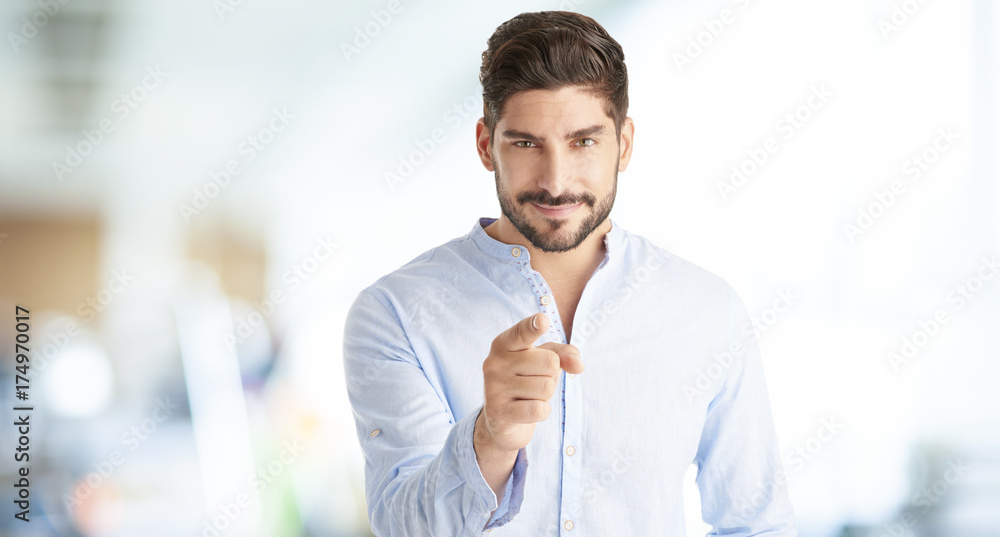 Naklejka premium Hey you. Young sales businessman looking at you and pointing at the camera