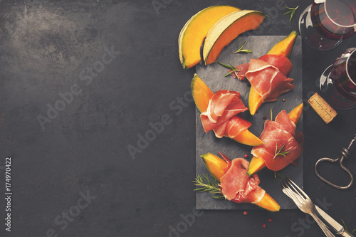 Fotografia Prosciutto ham with cantaloupe melon. Italian antipasti snack