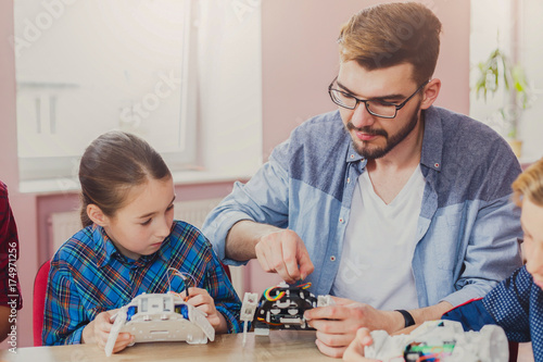 Stem education. Kids creating robots with teacher