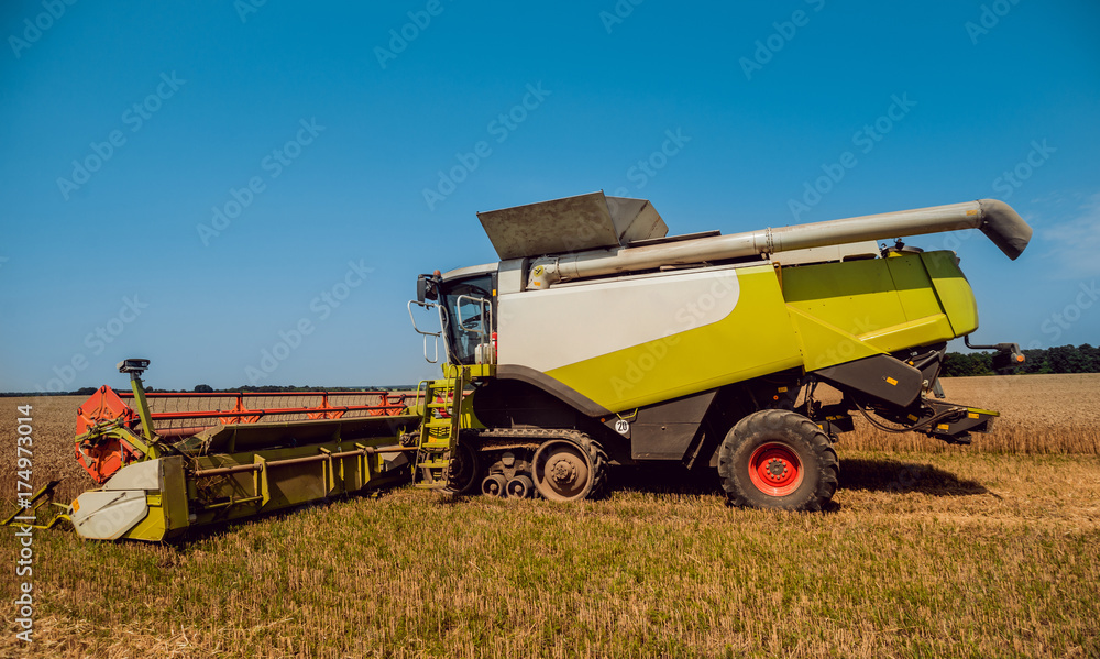 Combine harvester in action on wheat field. Process of gathering a ripe crop. Combine harvester in action on wheat field. Process of gathering a ripe crop.